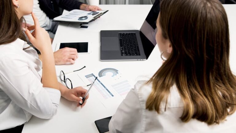 Business professionals collaborating on tech projects in a modern office setting.