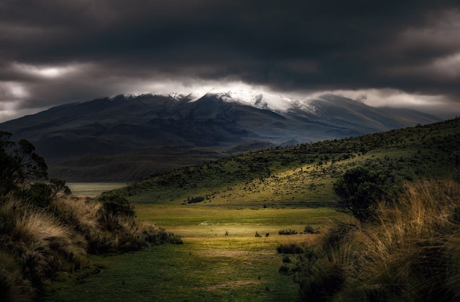 Stunning mountain landscape with dramatic dark clouds and green terrain.
