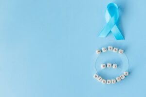 Flat lay of blue ribbon and letter blocks spelling 'World Diabetes Day' on a blue background.