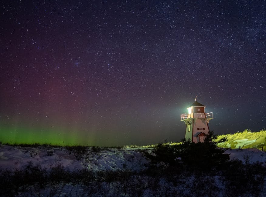 Stunning view of a lighthouse under the northern lights in Prince Edward Island's snowy landscape.