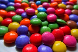 Close-up image of vibrant candy-coated chocolates in assorted colors on a white background.