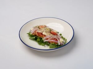 Delicious fresh salad with tomatoes, sprouts, onions, and garlic on a white background.