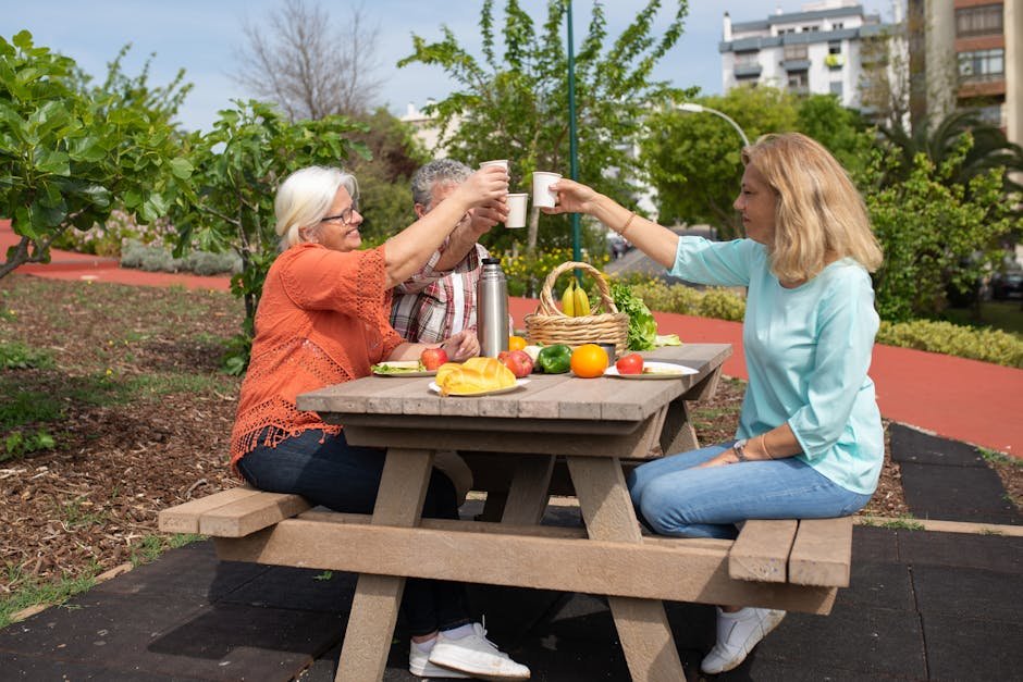 Three seniors celebrating a picnic outdoors with fresh food and drinks in Portugal.